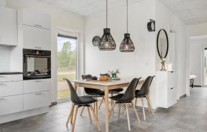 a kitchen with a wooden table and black chairs at 3 Bedroom Gorgeous Home In Ringkøbing in Ringkøbing