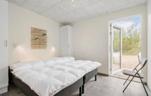 a large bed in a room with a window at 3 Bedroom Gorgeous Home In Ringkøbing in Ringkøbing +10 photos
