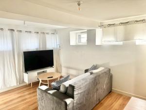a living room with a couch and a flat screen tv at Appartements meublés Brest Gay Lussac in Brest