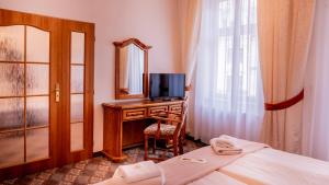 una camera da letto con una scrivania, uno specchio e un letto di Hotel Praga a Karlovy Vary