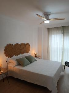 a bedroom with a large bed with a ceiling fan at Apartamento Crismar in Ronda