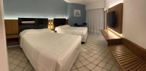 een hotelkamer met 2 bedden en een flatscreen-tv bij HOTEL PIRÂMIDE NATAL in Natal