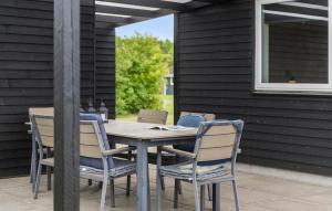 a wooden table and chairs on a patio at Pet Friendly Home In Hemmet With Wifi in Hemmet +18 photos