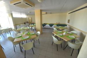 a dining room with tables and chairs in a restaurant at Rede Andrade Plaza Salvador in Salvador