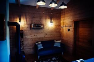 a living room with a blue couch and wooden walls at Ferienhaus am Teich in Kappel am Krappfeld