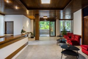 a living room with a red couch and tables at Garden House - Hotel Sport in Levico Terme