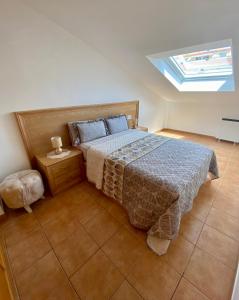ein Schlafzimmer mit einem Bett und einem Dachfenster in der Unterkunft Chalet Portosin con piscina al lado de la playa in Goyanes