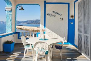 a table and chairs on a balcony with a view of the ocean at B&B AcquaDolce in Cala Gonone