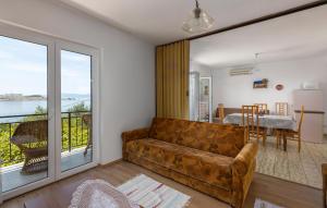 a living room with a couch and a balcony at Lovely Apartment In Omisalj With Wi-Fi in Omišalj