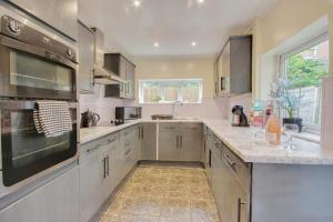 una cocina con electrodomésticos de acero inoxidable y fregadero en Entire 3 bed house in Gloucester, en Gloucester