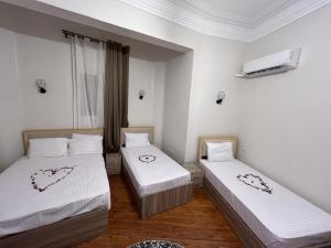 two beds in a room with white walls at Downtown view studios in Cairo