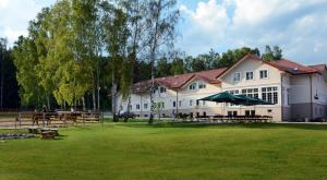 um grande edifício branco com mesas de piquenique num quintal em Świętokrzyska Polana - Medical Resort em Chrusty