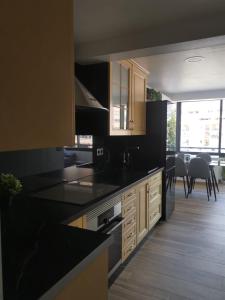 a kitchen with black counter tops and a dining room at Blue Ocean Apartments in Benalmádena