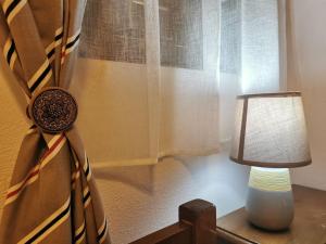 a lamp sitting on a table next to a window at Rent Apartment - SKALA ERESOS LESVOS in Skala Eresou
