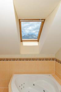a bathroom with a bath tub and a window at Vila Tatranka in Stará Lesná