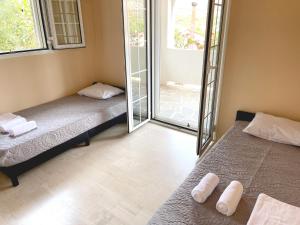 two beds in a room with a sliding glass door at Sounio Poseidon Villa in Sounio