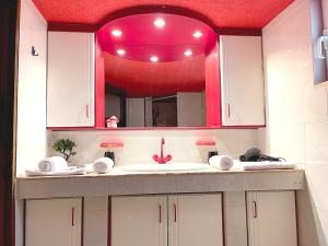 a bathroom with a sink and a pink mirror at Sounio Poseidon Villa in Sounio