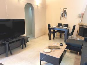 a living room with a flat screen tv and a table at Sounio Poseidon Villa in Sounio