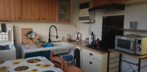 a small kitchen with a table and a microwave at Le Skyline - 3 Chambres Indépendantes, lits doubles in Nantes