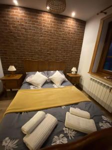 1 cama con 2 almohadas y toallas en Domek Balowa Góra, en Osówka