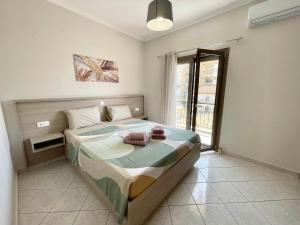 a bedroom with a bed with towels on it at Litsa's Luxury Apartment in Igoumenitsa