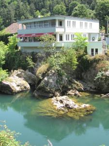 a building on a hill next to a river at Motel Kobilj in Banja Luka