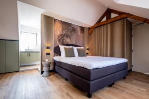a bedroom with a large bed with a painting on the wall at BB aan de kapel in Roermond