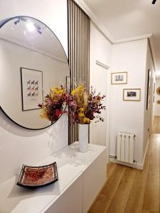 a room with a mirror and flowers on a counter at Apartamento I Cruces Metro BEC in Barakaldo
