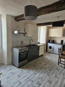 a kitchen with a stove and a sink in it at Le papey in Molières-Cavaillac