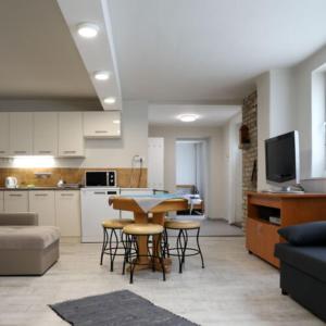 a kitchen and living room with a table and chairs at Róza Vendégházak- Tényő in Tényő