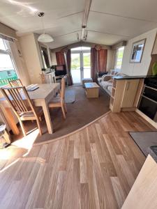 a kitchen and living room with a table and chairs at Van number 123 Beautiful Caravan sleeps 4 in Aberystwyth