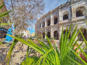 an old building with tables and chairs in front of it at Le Plaisant - Nîmes plein centre in Nîmes
