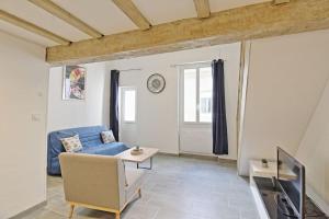 a living room with a blue couch and a tv at Le Plaisant - Nîmes plein centre in Nîmes