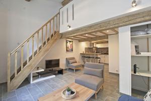 a living room with a staircase and a couch and chairs at Le Plaisant - Nîmes plein centre in Nîmes