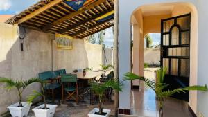a patio with a table and chairs and plants at Maasai Hostel Tanzania in Arusha
