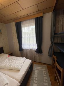 a bedroom with a bed and a window at Ferien-Bungalow im Seebad UeckermündeOT Bellin in Ueckermünde
