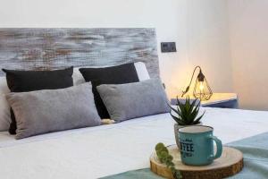 a bed with a coffee cup and a plant on a tray at Bungalow Pink Palm beach in Torrevieja +32 photos