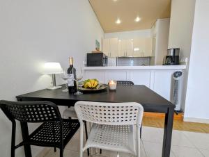 a dining room table with two chairs and a bottle of wine at Apartment in Club Paraiso Ocean View, Wi-Fi in Playa Paraiso