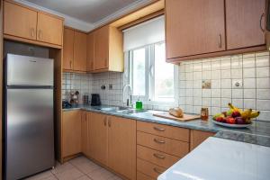a kitchen with wooden cabinets and a stainless steel refrigerator at Erasmia's house in Lakíthra