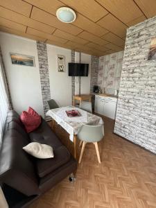 a living room with a table and a couch at Ferien-Bungalow im Seebad UeckermündeOT Bellin in Ueckermünde