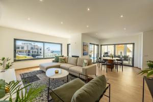 a living room with a couch and a table at Silver Coast Beach Villa-Casa de Luxo com Piscina e Vista Mar in Lourinhã