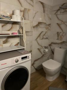 a bathroom with a washing machine and a toilet at Casa Venti Perea in Perea +38 photos