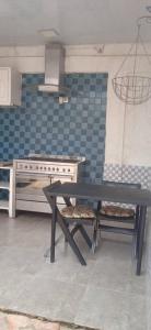 a table and bench in a kitchen with a stove at La Résidence in Lomé