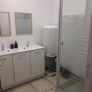 Un baño con dos lavabos y una ducha. en au centre de saint Léonard, en Saint-Léonard-de-Noblat