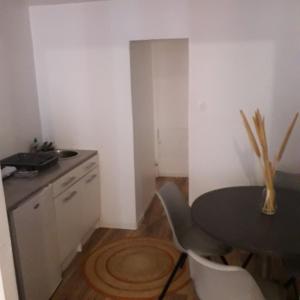 Una cocina con una mesa y sillas y un fregadero. en au centre de saint Léonard, en Saint-Léonard-de-Noblat