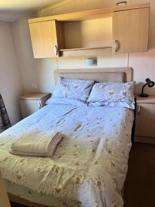 sypialnia z łóżkiem z białą kołdrą w obiekcie Van number 123 Beautiful Caravan sleeps 4 to 6 w Aberystwyth