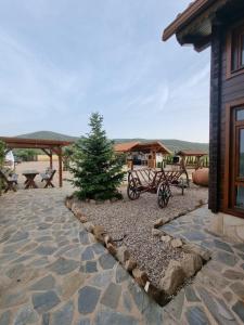 a patio with benches and a pine tree in a yard at Casa rural Cabaña de la Huerta in Navahermosa