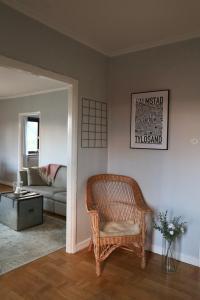 a living room with a wicker chair and a couch at Lägenhet nära hav och centrum in Halmstad