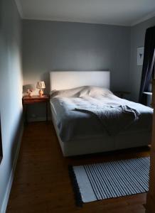 a bedroom with a bed and a table with a lamp at Lägenhet nära hav och centrum in Halmstad