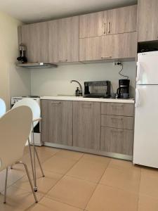 a kitchen with wooden cabinets and a white refrigerator at Yalos Studio in Stavros